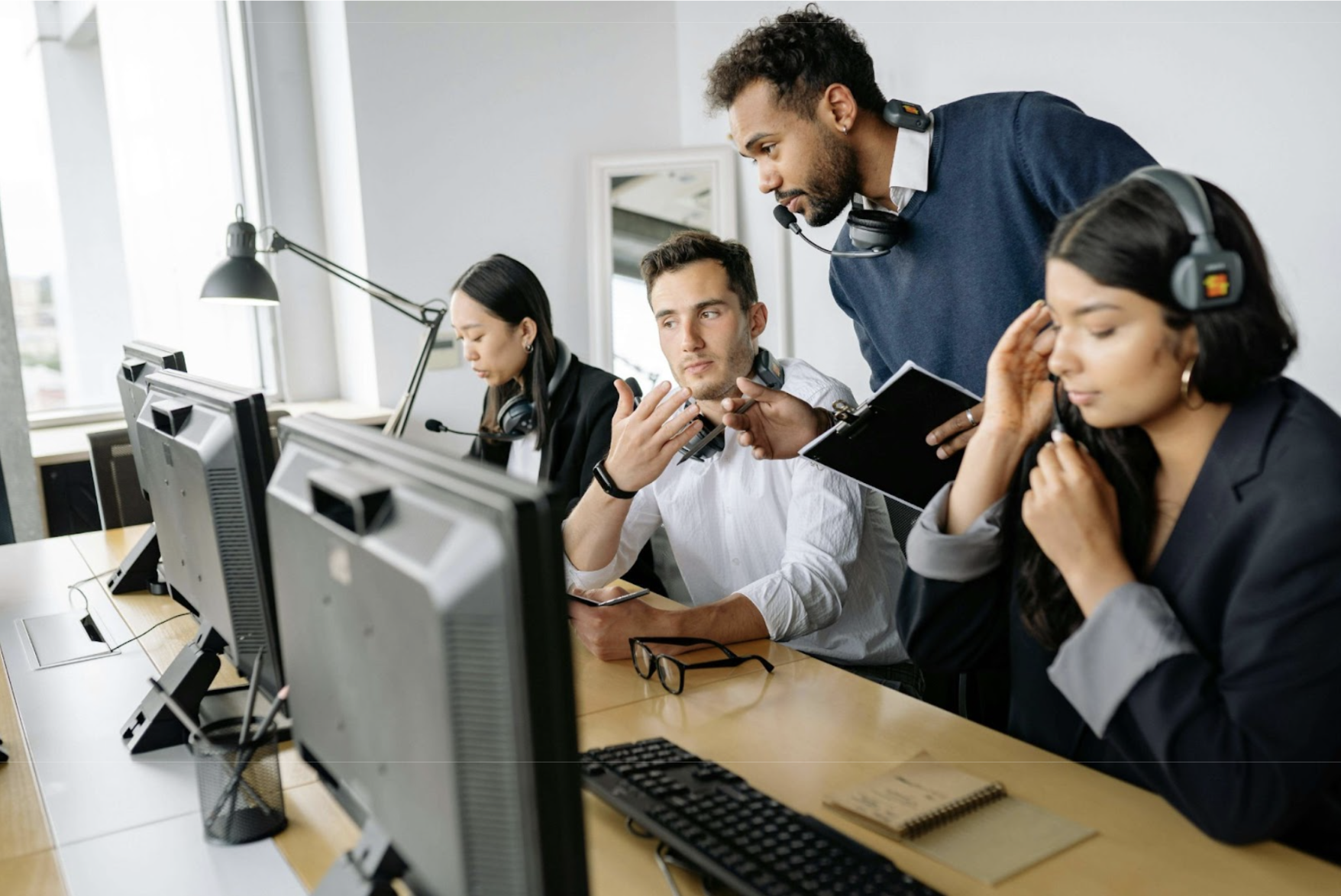 A manager shows an employee how to use something on his computer